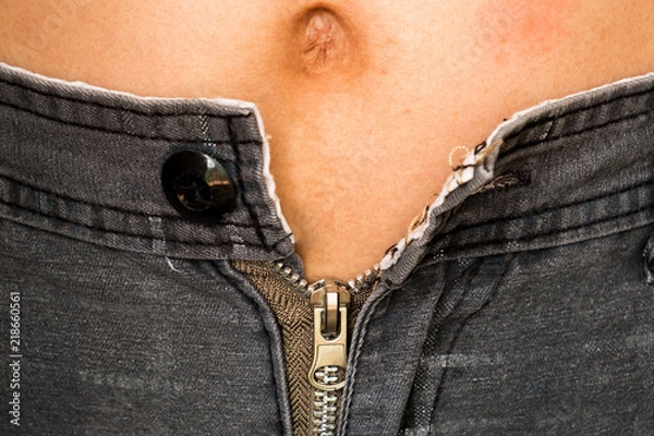 Fototapeta A overweight man can't tight his pants because his fats in belly. He needs a gym to firming his shape.