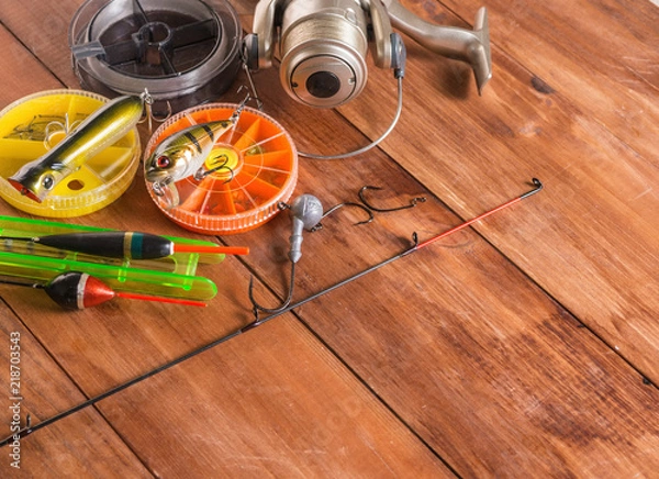 Fototapeta Floats, spinning and boxes with baits on a wooden background