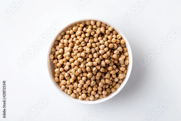 Fototapeta Closeup top view bowl of uncooked chickpeas isolated at white background.
