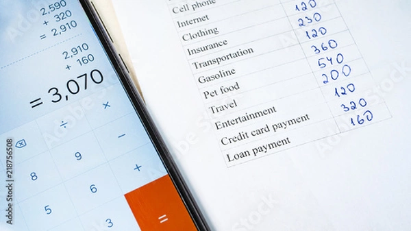 Fototapeta Home budget planning sheet with pen and smart phone calculator