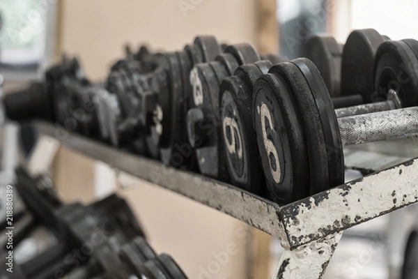 Fototapeta Rack with dumbbells in the old gym