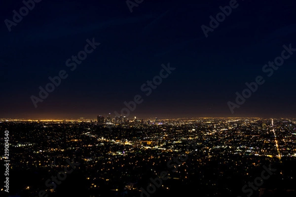 Fototapeta View of the downtown Los Angeles skyline at night, from Griffith Observatory, in Griffith Park, Los Angeles, California.