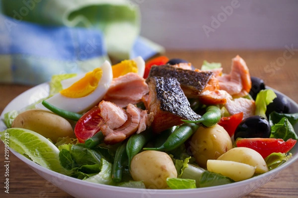 Fototapeta Salad Nicoise with salmon. Tomato, green beans, new potato, olives and lettuce salad with salmon. horizontal