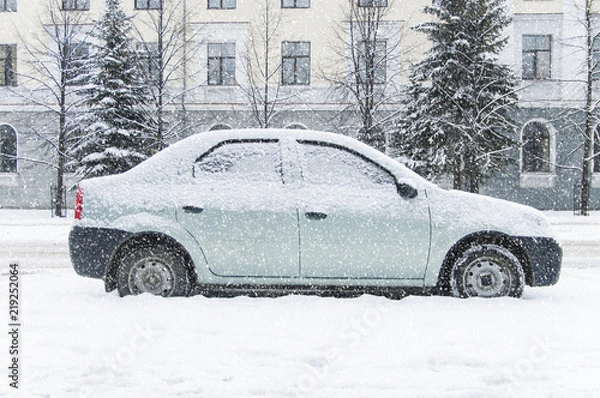 Obraz A car parked on the street, covered with snow