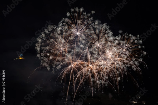 Fototapeta Wonderful fireworks on the feast of the patron saint of the city whose church is visible in the background, Vittorio Veneto, Italy