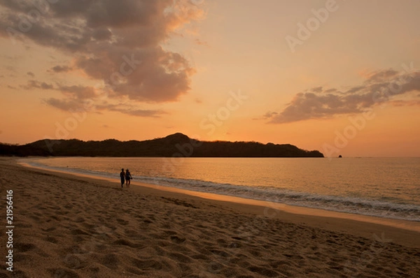 Obraz Romantic beach sunset young couple holding hands.