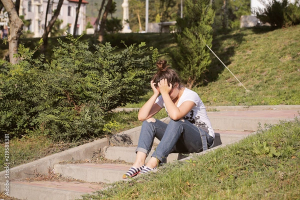 Fototapeta девушка подросток сидит в парке и плачет 