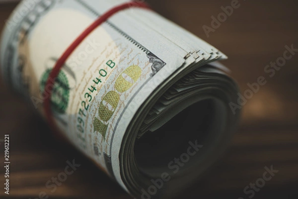 Obraz US dollars in roll on money background