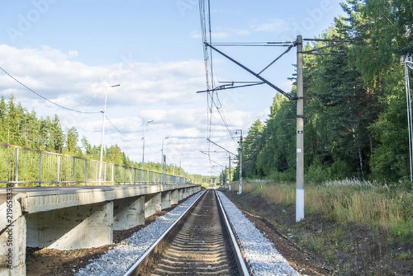 Fototapeta A view at the and railroad sleepers going through the forest