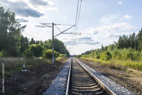Fototapeta A view at the and railroad sleepers going through the forest