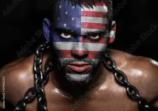 Fototapeta American flag on the face of a young man in chains