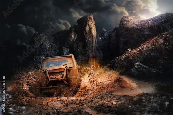 Fototapeta Pojazd terenowy wychodzący z błotnistej dziury, błota i rozbryzgów wody w wyścigach terenowych.