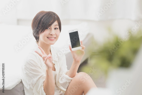 Fototapeta スマホ・女性・ベッドルーム