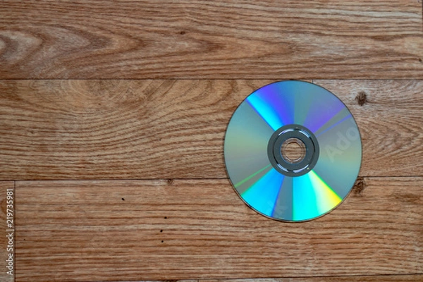 Obraz Single DVD disk lying on a wooden table with space beside