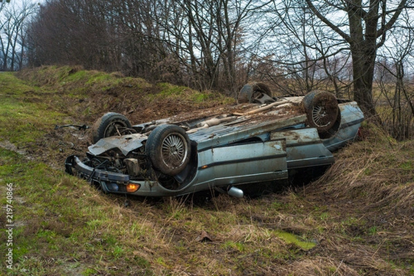 Obraz The car got into an accident on the highway. The blue car turned over in a ditch near the highway.