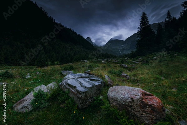 Fototapeta Mysterious and mystical view of the night mountains. Dramatic cloudy sky and mountain peaks in the fog. Fagaras Mountains.Transylvania. Romania.