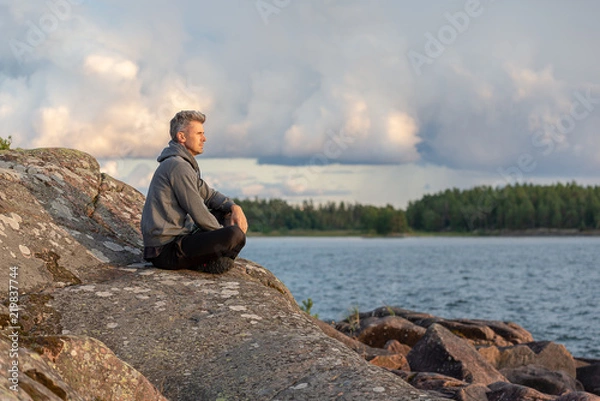 Fototapeta Man sitting by the lake