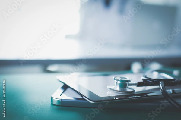 Fototapeta Sprzęt medyczny: niebieski stetoskop i tabletki na białym tle. Wyposażenie medyczne