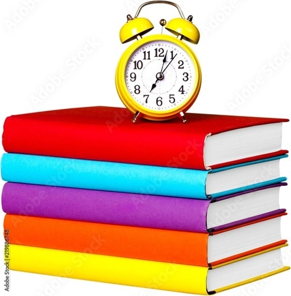 Fototapeta Alarm Clock On Stacked Books - Isolated