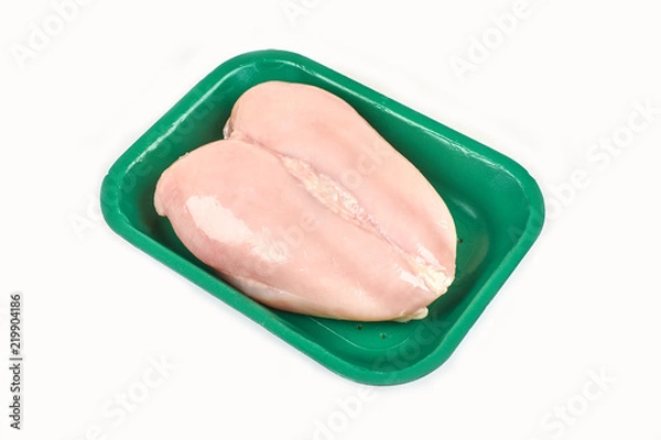Fototapeta Raw chicken breast in a tray on a white background.