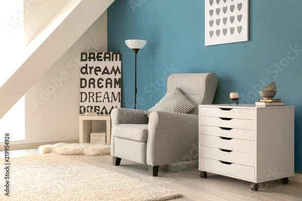Fototapeta Stylish interior of living room with comfortable armchair and commode near color wall
