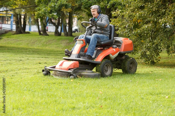 Fototapeta Ciągnik kosiarki pracujący w parku miejskim