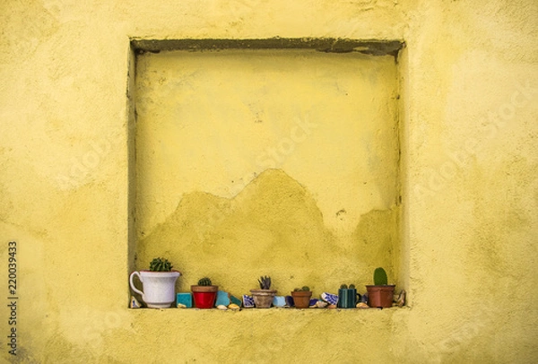 Obraz Yellow walls with niche with succulents in Mexico style