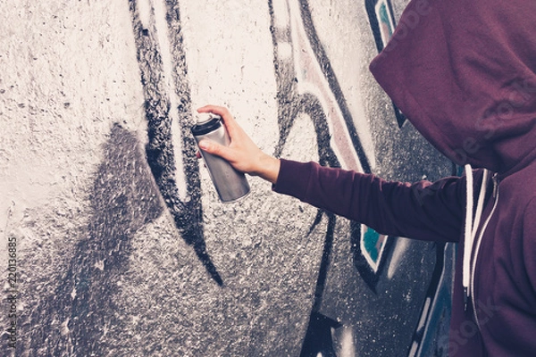 Fototapeta na wymiar Artysta graffiti z butelką w aerozolu blisko ściany