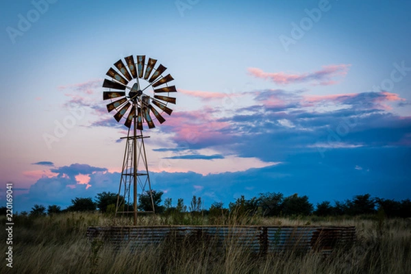 Fototapeta Sunset windmill with colorful clouds