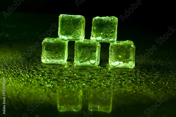 Fototapeta Green ice cubes on black background.
