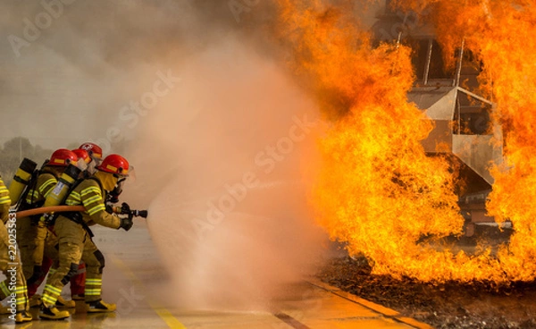Obraz Some firemen fighting a great fire. Firefighters doing some training.