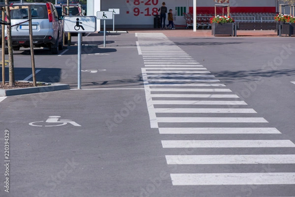 Obraz Nowo wykonany parking przy centrum handlowym w centrum miasta z terenami zielonymi i przejściem dla pieszych. Strzałki i znaki na asfalcie pokazujące zasady i wskazówki
