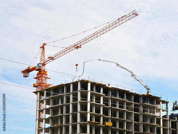 Fototapeta Skyscraper construction. Crane near concrete building under constriction. Construction site.