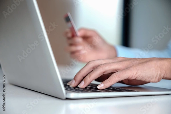 Fototapeta Online payment,Woman's using computer laptop and hand holding credit card for online shopping.
