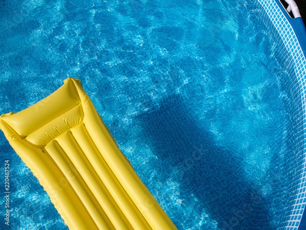 Fototapeta Top view of an inflatable mattress in a backyard swimming pool
