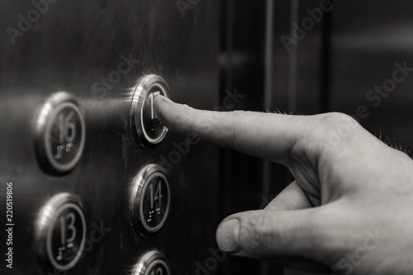 Obraz the man presses the elevator button. black and white.