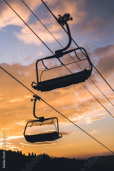 Fototapeta Silhouette of chair lifts on Vail Mountain with an Orange sunset in the background. 