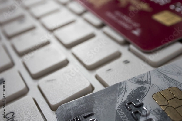 Fototapeta Close up credit card lie on white computer keyboard. Concept of internet purchase. Bank Credit Card on a Computer Keyboard