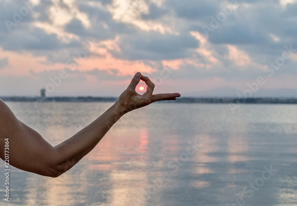 Obraz sunset over the sea captured between two fingers
