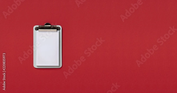 Fototapeta Clipboard on red horizontal background. Flat lay, top view trendy for banner