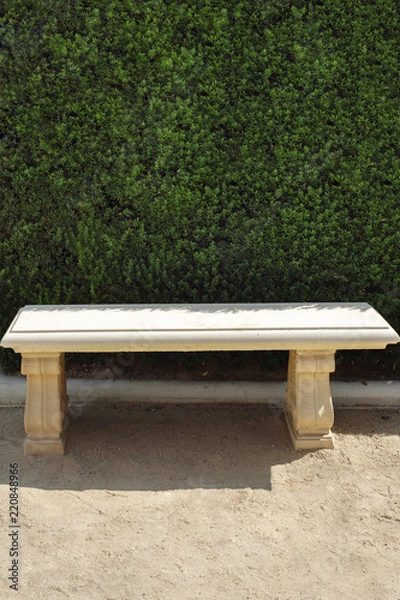 Obraz Park bench with green bushes behind and copy space