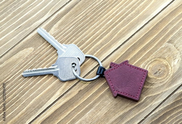 Fototapeta keychain with house symbol and keys on wooden background,Real estate concept