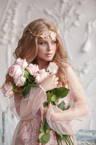 Obraz Delicate portrait of a young model girl. The image of the bride, a light lace dress in pink, a beautiful hairstyle and a natural make-up. Light photo studio, natural light from the window.