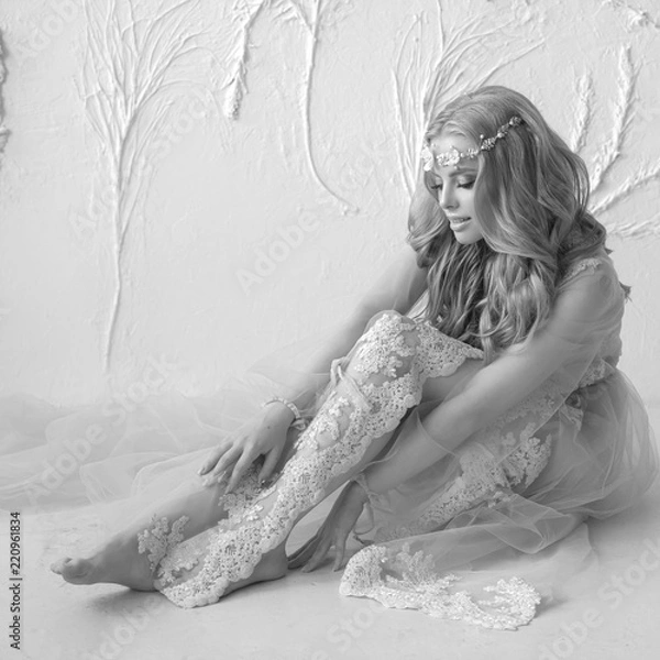 Obraz Delicate portrait of a young model girl. The image of the bride, a light lace dress in pink, a beautiful hairstyle and a natural make-up. Light photo studio, natural light from the window.