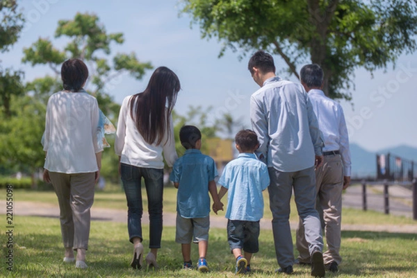 Obraz 手を繋いで公園を歩く三世代家族の後ろ姿