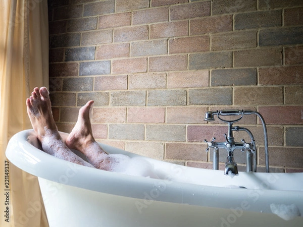Obraz Men's  feet covered with foam bubble bath  in luxury bathtub with happiness and relaxing