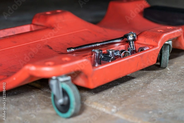 Obraz Auto repair shop tools on a creeper in a garage