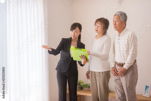 Obraz 住宅を内見するシニア夫婦と不動産会社のビジネスウーマン