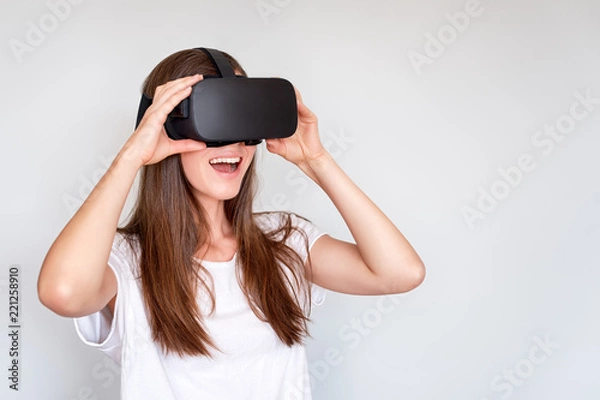 Obraz Uśmiechnięta pozytywna kobieta jest ubranym rzeczywistość wirtualna gogle słuchawki, vr pudełko. Połączenie, technologia, nowa generacja, koncepcja postępu. Dziewczyna próbuje dotykać obiektów w wirtu