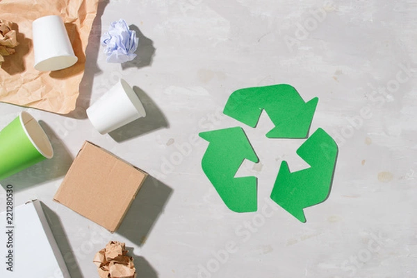 Obraz recycling symbol with waste on wooden background top view